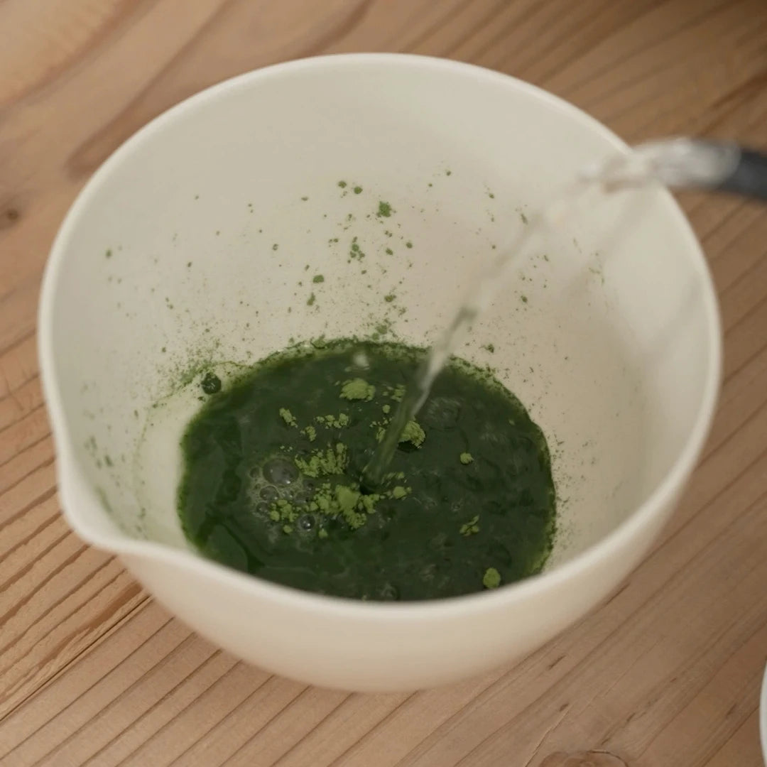 Boiled water being poured into the sifted matcha inside the Matcha Bowl.