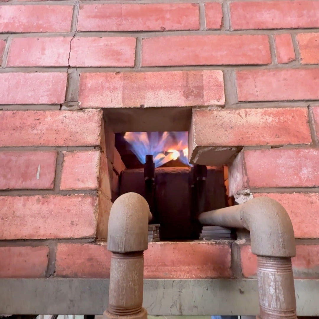 Brick wall with a fireplace opening and pipes