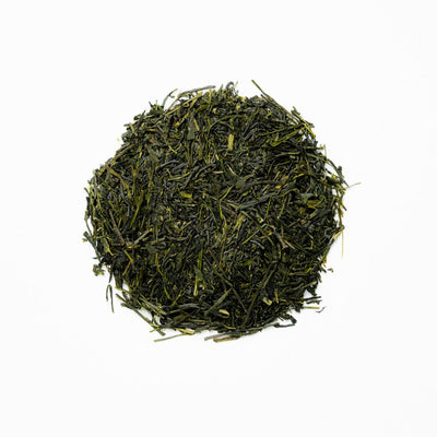 A pile of Goraiko Sencha green tea leaves on a white background