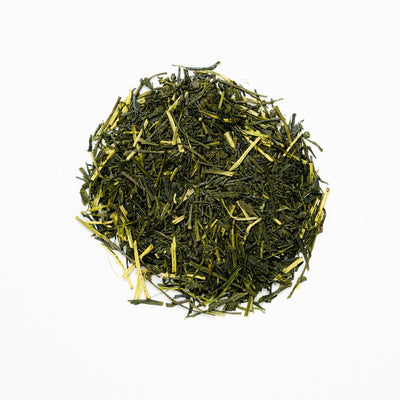 A pile of Mikazuki Sencha green tea leaves on a white background