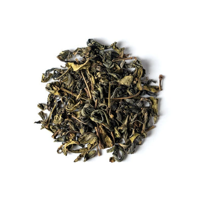A pile of Sencha green tea leaves on a white background